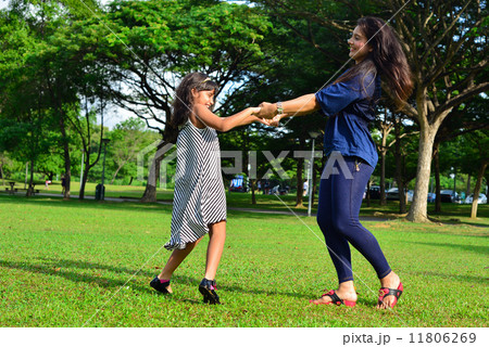 Young Asian mother and her cute daughter playing in the outdoor garden Young Asian mother and her cute daughter playing in the outdoor garden 11806269