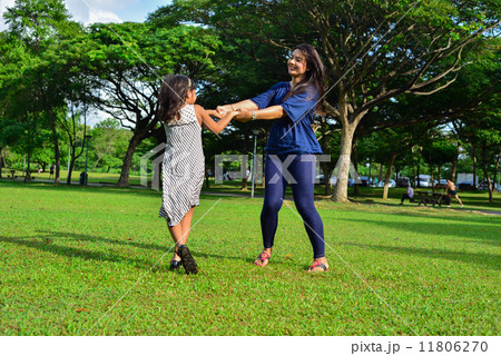 Young beautiful Asian mother and her cute daughter playing in the outdoor garden 11806270