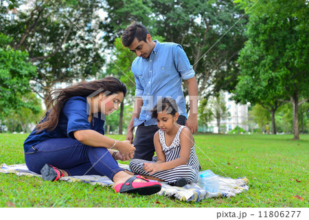 Young asian family spending time on a picnic mat at the park Young asian family spending time on a picnic mat at the park 11806277