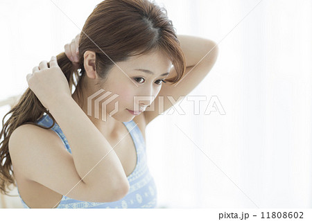 髪を束ねる女性の写真素材