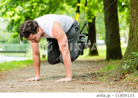man in city park doing suspension trainer sport 11809133