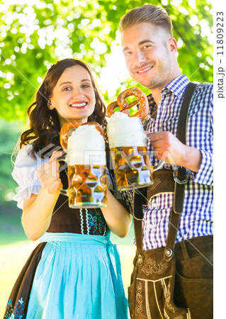 German couple in Tracht drinking beer 11809223