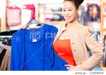 Asian Woman choosing clothes in fashion shop Asian Woman choosing clothes in fashion shop 11809648