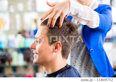 Hairdresser cutting man hair in barbershop Hairdresser cutting man hair in barbershop 11809752
