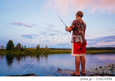 Belarusian Boy Fishing From Old Boats At Sunset Of A Summer Day 11824996