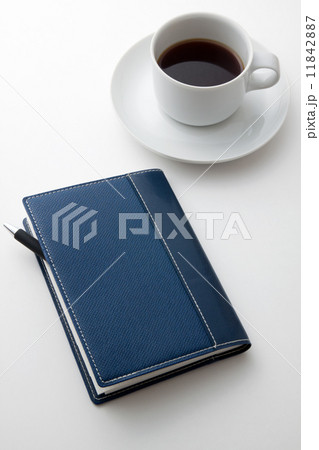 コーヒーを飲みながら手帳に予定を記入 11842887