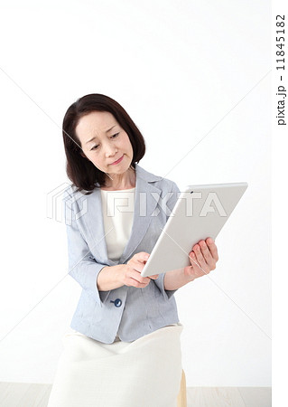 タブレットを見て困った顔をする女性 11845182