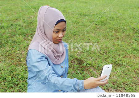 公園で携帯を見るアジア人女子 公園で携帯を見るアジア人女子 11848568