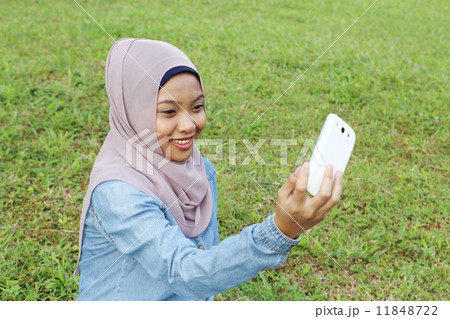 公園で携帯を見るアジア人女子 11848722
