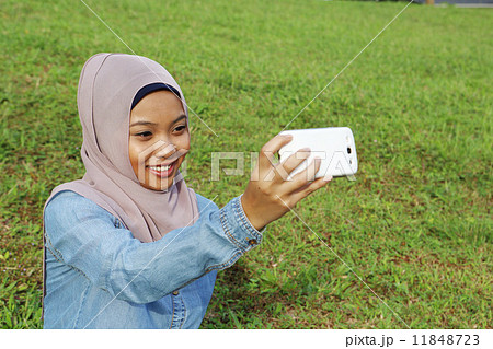 公園で携帯を見るアジア人女子 公園で携帯を見るアジア人女子 11848723