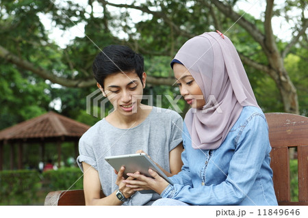 公園でタブレットを使うアジア人カップル 11849646