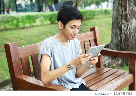 公園でタブレットを使っているアジア人 11849732