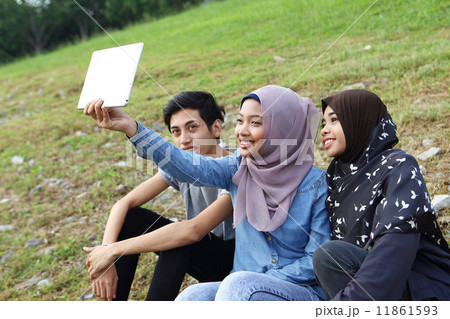 公園でタブレットを見る3人のアジア人 公園でタブレットを見る3人のアジア人 11861593