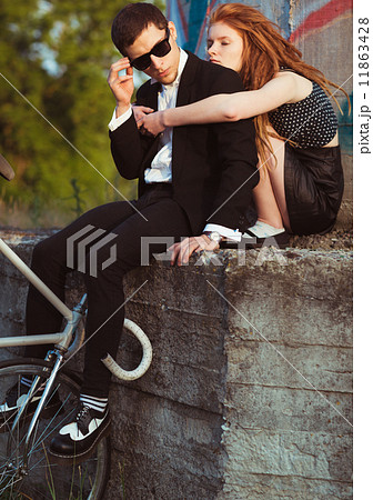 Young stylish guy with girl and the bicycle outdoors Young stylish guy with girl and the bicycle outdoors 11863428