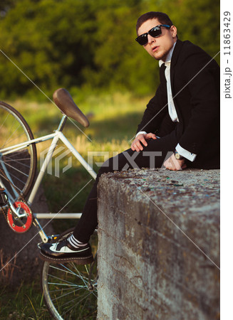 Young stylish guy with bicycle outdoors Young stylish guy with bicycle outdoors 11863429