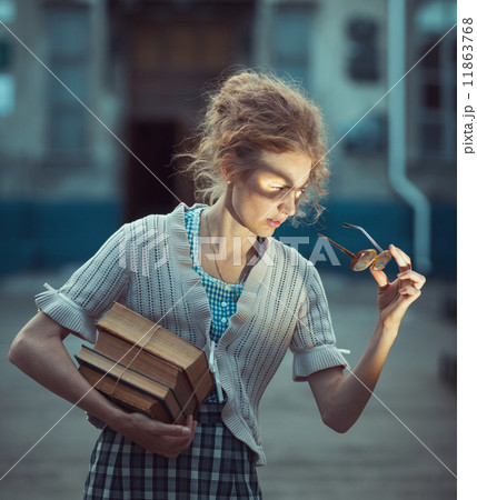 Funny girl student with books and glasses and a vintage dress Funny girl student with books and glasses and a vintage dress 11863768