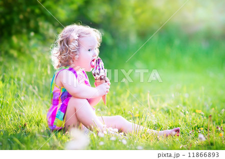 Funny girl eating ice cream in the garden Funny girl eating ice cream in the garden 11866893