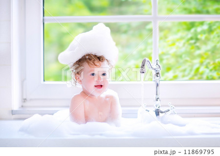 Funny baby girl playing with water and foam in a big kitchen sin Funny baby girl playing with water and foam in a big kitchen sin 11869795