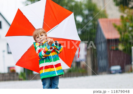 Smiling boy with yellow umbrella and colorful jacket outdoors at Smiling boy with yellow umbrella and colorful jacket outdoors at 11879048