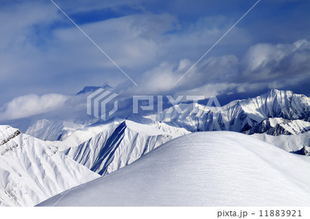 Off-piste snowy slope and cloudy mountains 11883921