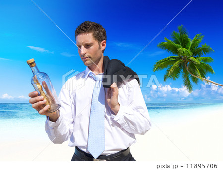 Businessman Looks at Message in a Bottle 11895706