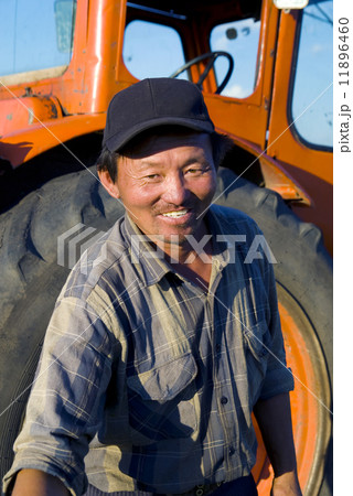 Mongolian Farmer Standing In Front Of His Tractor Reaching Forwa 11896460
