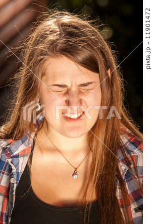 portrait of brunette woman wincing of bright light 11901472