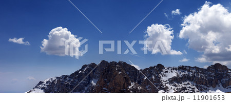 Panorama of snowy rocks and blue sky with clouds 11901653