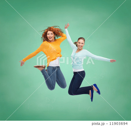 smiling young women jumping in air smiling young women jumping in air 11903694