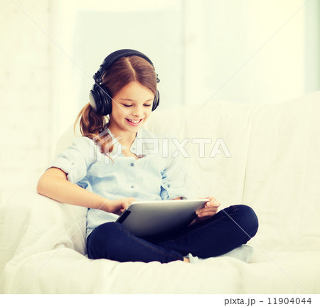 girl with tablet pc and headphones at home 11904044