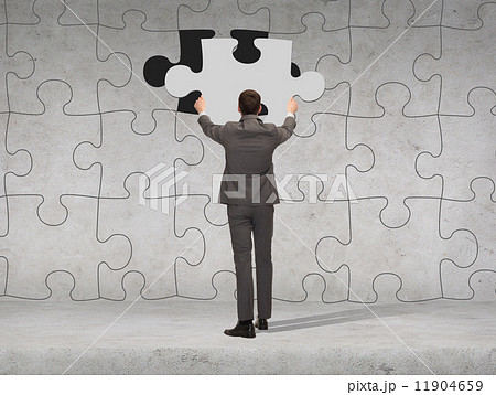 businessman in suit setting piece of puzzle 11904659