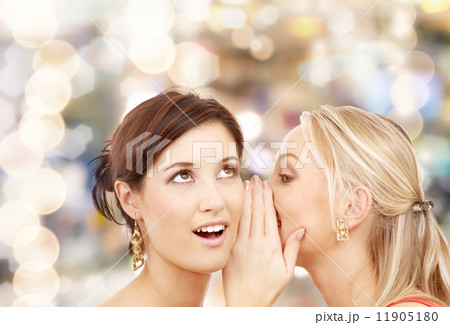 two smiling women whispering gossip two smiling women whispering gossip 11905180