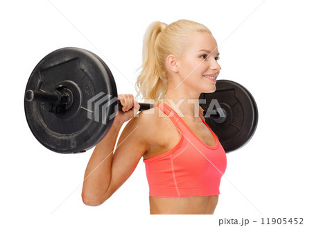 smiling sporty woman exercising with barbell 11905452