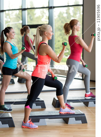 group of women with dumbbells and steppers group of women with dumbbells and steppers 11905696