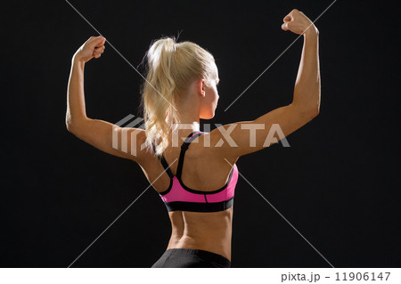 sporty woman from the back flexing her biceps sporty woman from the back flexing her biceps 11906147