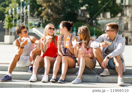 group of smiling friends sitting on city square group of smiling friends sitting on city square 11906510
