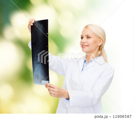 smiling female doctor looking at x-ray smiling female doctor looking at x-ray 11906587