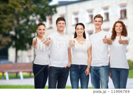 smiling teenagers in t-shirts showing thumbs up smiling teenagers in t-shirts showing thumbs up 11906769