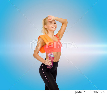 smiling sporty woman with towel and water bottle smiling sporty woman with towel and water bottle 11907523