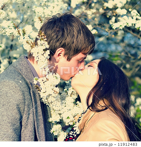 spring outdoor portrait of a young couple kissing 11912483