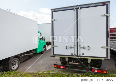 Rear view of new standing white cargo trucks 11913655