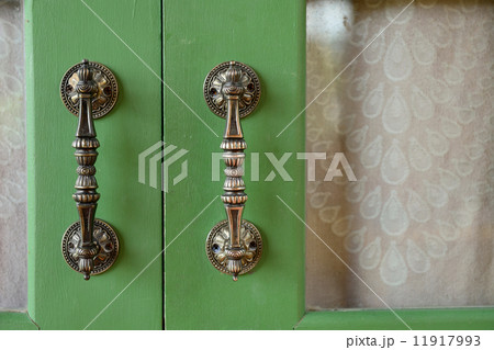 Door handle on green wooden door 11917993