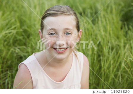 A young girl smiling, sitting on the ground. A young girl smiling, sitting on the ground. 11925820