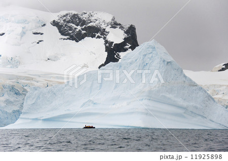 People in small inflatible zodiac rib boats passing icebergs and ice floes on the calm water around small islands of the Antarctic. People in small inflatible zodiac rib boats passing icebergs and ice floes on the calm water around small islands of the Antarctic. 11925898