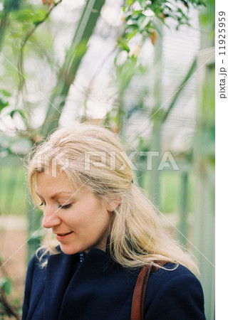 A blonde haired woman in a conservatory or tropical plant house. A blonde haired woman in a conservatory or tropical plant house. 11925959