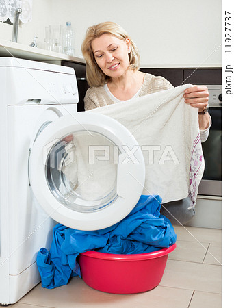 housewife looking at clothes near washing machine housewife looking at clothes near washing machine 11927737