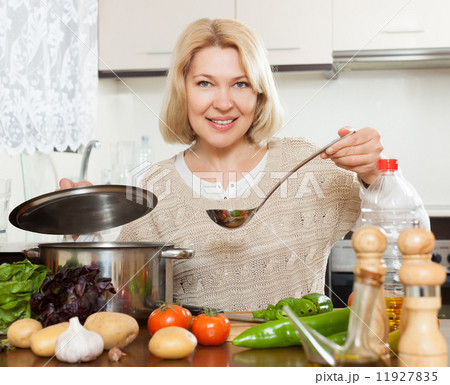 Beautiful mature woman cooking soup Beautiful mature woman cooking soup 11927835