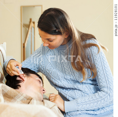 Girl dripping eardrops to man Girl dripping eardrops to man 11928101