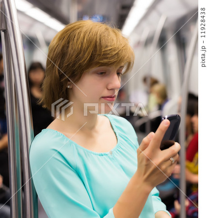 Girl using smartphone in subway Girl using smartphone in subway 11928438