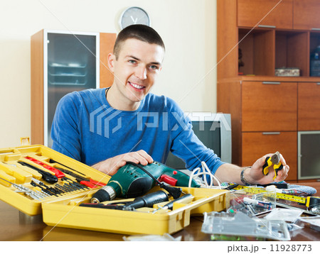 Happy smiling man organizing toolbox Happy smiling man organizing toolbox 11928773